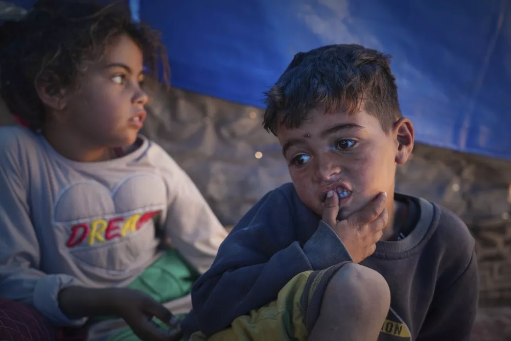 Raed Zaharna, right, and his sister Sally sit in their family tent after their mother, Ward, returned empty-handed from trying to receive donated food at a community kitchen in Khan Younis, in the southern Gaza Strip, Friday, May 9, 2025. (AP Photo/Abdel Kareem Hana)