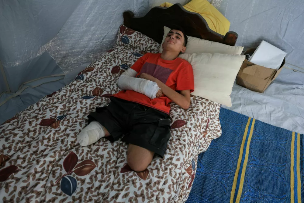 Ahmad Al-Ghalban, a 16-year-old Palestinian gymnast, who lost both his legs in an Israeli airstrike on Beit Lahiya, lies propped up on his bed inside the tent he took shelter in, after being displaced, in Gaza City, May 21, 2025. REUTERS/Dawoud Abu Alkas
