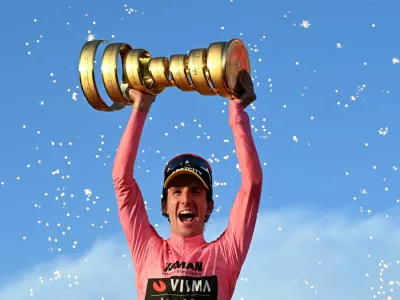Cycling - Giro d'Italia - Stage 21 - Rome to Rome - Italy - June 1, 2025 Team Visma | Lease a Bike's Simon Yates celebrates with a trophy on the podium after winning the Giro d'Italia REUTERS/Jennifer Lorenzini   TPX IMAGES OF THE DAY