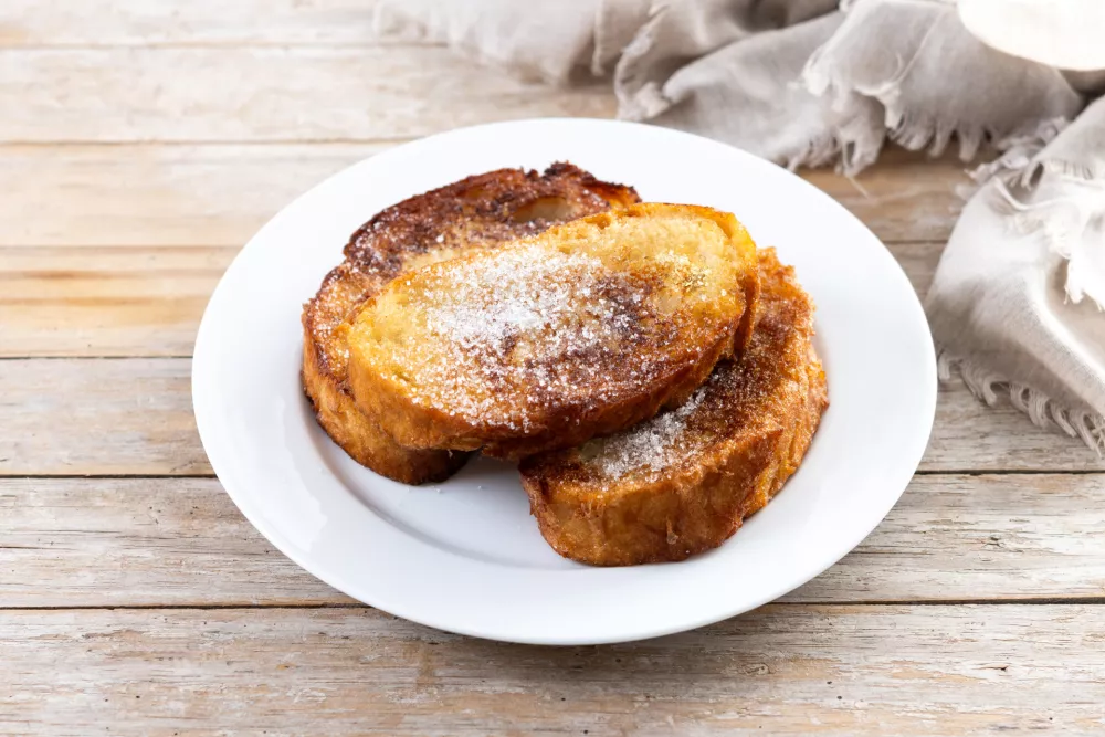 Traditional Spanish torrijas for Holy Week on wooden table. French Toast / Foto: Etorres69