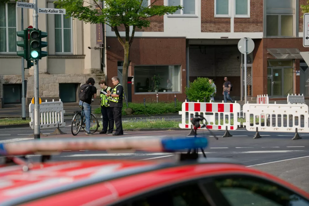 04 June 2025, North Rhine-Westphalia, Cologne: Employees of the public order office explain the road closures due to a bomb disposal operation to passers-by. On Monday, three bombs from the Second World War were discovered in the Deutz district. Photo: Henning Kaiser/dpa