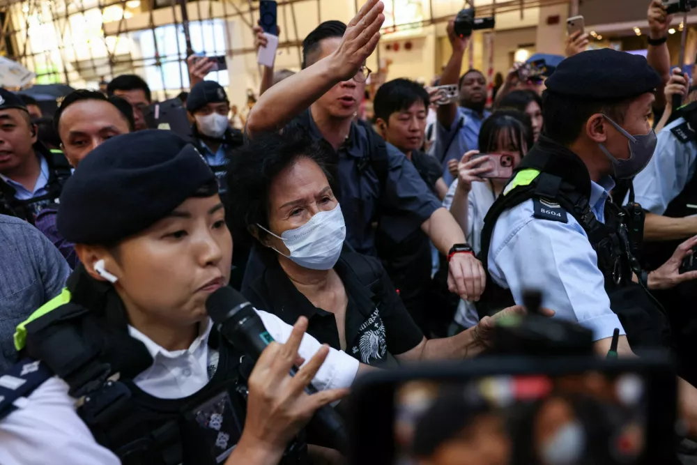 A woman is escorted by the police to leave after holding a flower near Victoria Park during the 36th anniversary of the crackdown on pro-democracy demonstrators at Beijing's Tiananmen Square in 1989, in Hong Kong, China, June 4, 2025. REUTERS/Tyrone Siu