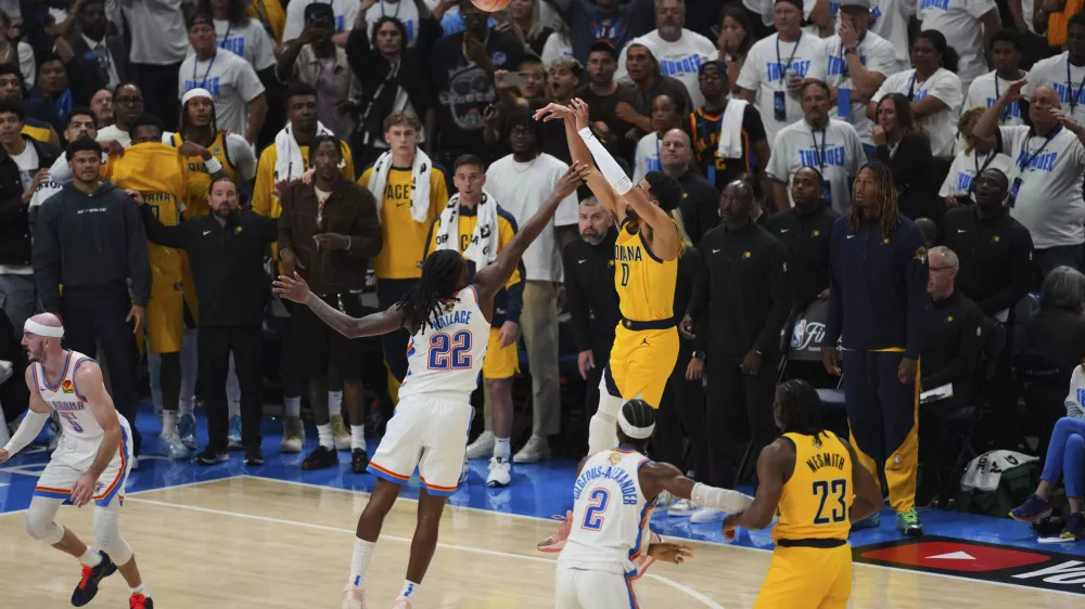 Indiana Pacers guard Tyrese Haliburton (0) shoots a 3-pointer against Oklahoma City Thunder guard Cason Wallace (22) during the second half of Game 1 of the NBA Finals basketball series Thursday, June 5, 2025, in Oklahoma City. (AP Photo/Nate Billings)