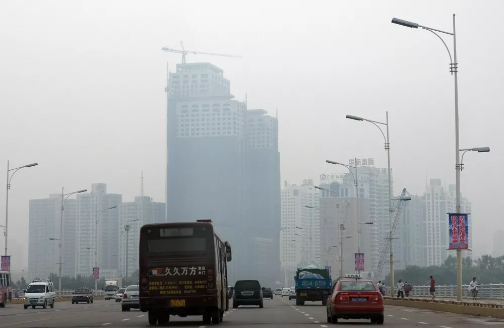 **FILE** Motorists drive toward to the city center, shrouded with haze in Shenyang, outskirt of Beijing, China, in a Wednesday, Aug. 15, 2007 file photo. Athletes face a conundrum if Beijing's polluted air doesn't improve for next year's Olympics: stay away as long as possible, or come in early and get used to it. Track and field stars are weighing their options. (AP Photo/Andy Wong, File)