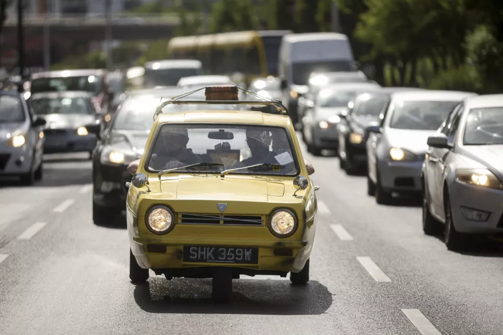 Tarik Fatic along with his brother Mirnes drives the Reliant Regal, an exact copy of the famous BBC TV show  "Only Fools and Horses" iconic yellow car in Sarajevo, Bosnia, Wednesday, June 4, 2025. (AP Photo/Armin Durgut)
