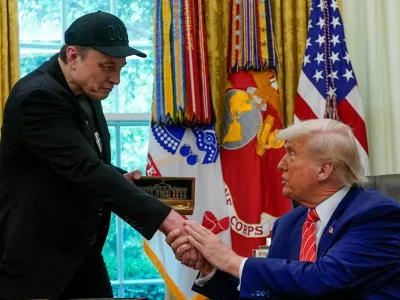 FILE PHOTO: Elon Musk receives a golden key from U.S. President Donald Trump in the Oval Office at the White House in Washington, D.C., U.S., May 30, 2025. REUTERS/Nathan Howard/File Photo