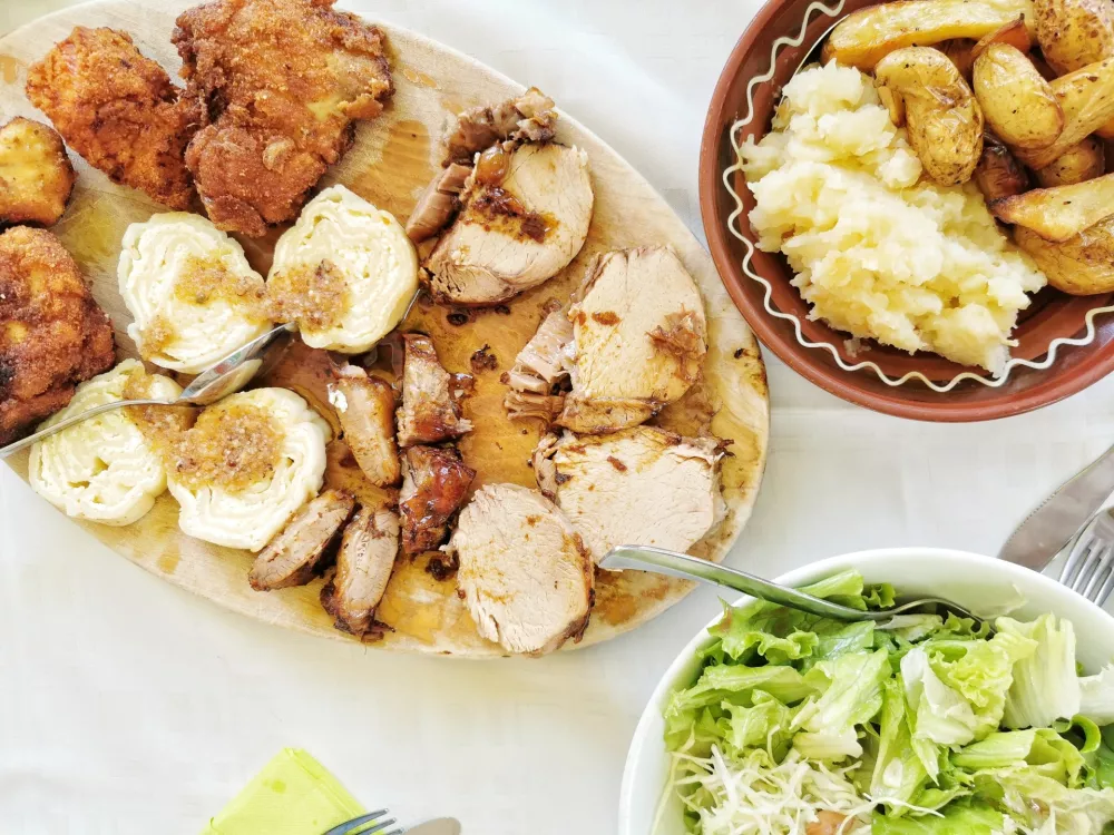 Pohana piška, svinjski kare in priloge / Foto: Miha First