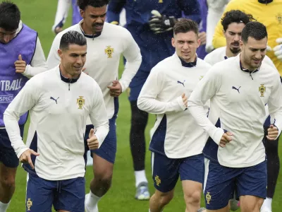 Portugal's Cristiano Ronaldo, left, and team mate Francisco Conceicao, center, warm up during a training session ahead of the Nations League soccer final match between Spain and Portugal in Munich, Germany, Saturday, June 7, 2025. (AP Photo/Matthias Schrader)