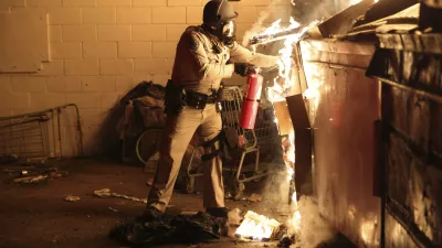 A law enforcement officer works to put out a fire during a protest in Compton, Calif., Saturday, June 7, 2025, after federal immigration authorities conducted operations. (AP Photo/Ethan Swope) / Foto: Ethan Swope