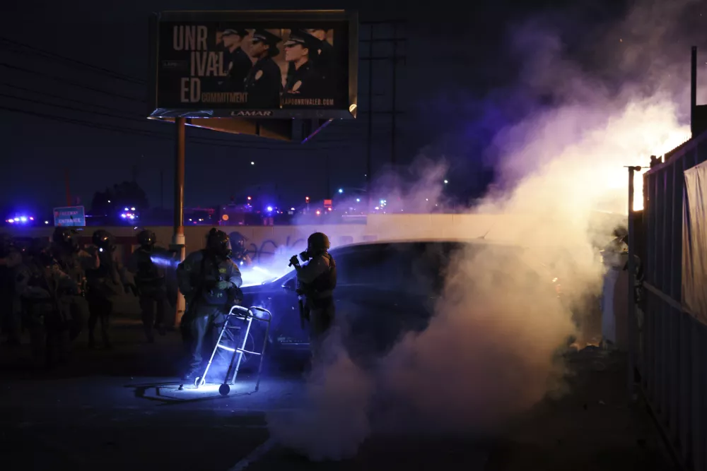 Law enforcement investigate a car with a person inside during a protest in Compton, Calif., Saturday, June 7, 2025, after federal immigration authorities conducted operations. (AP Photo/Ethan Swope) / Foto: Ethan Swope
