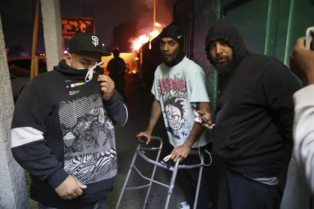 A man, center, stands with others after law enforcement helped him out of a car during a protest in Compton, Calif., Saturday, June 7, 2025, after federal immigration authorities conducted operations. (AP Photo/Ethan Swope) / Foto: Ethan Swope