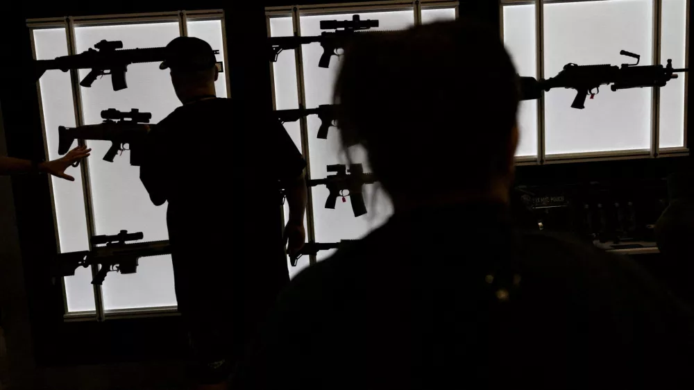 FILE PHOTO: A man looks at an AR-15 rife at an exhibition booth during the National Rifle Association (NRA) annual convention in Dallas, Texas, U.S., May 18, 2024. REUTERS/Carlos Barria/File Photo