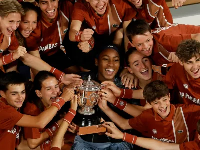 Tennis - French Open - Roland Garros, Paris, France - June 7, 2025 Coco Gauff of the U.S. celebrates with the trophy and the ball kids after winning the women's singles final against Belarus' Aryna Sabalenka REUTERS/Stephanie Lecocq   TPX IMAGES OF THE DAY