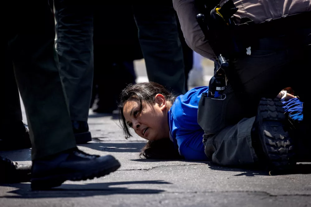 Los Angeles County Sheriff's deputies detain a woman during a standoff by protesters and law enforcement, following multiple detentions by Immigration and Customs Enforcement (ICE), in the Los Angeles County city of Compton, California, U.S., June 7, 2025.  REUTERS/Barbara Davidson REFILE - CORRECTING LOCATION FROM "PARAMOUNT" TO "COMPTON".