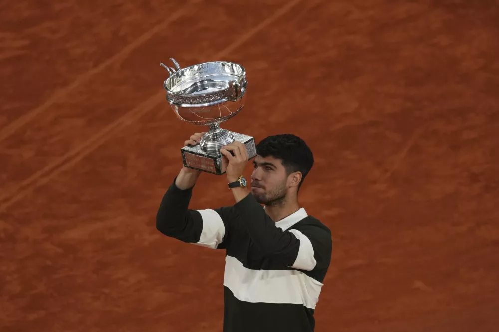 Spain's Carlos Alcaraz hold the trophy after winning the final match of the French Tennis Open at the Roland-Garros against Italy's Jannik Sinner in Paris, Sunday, June 8, 2025. (AP Photo/Aurelien Morissard)