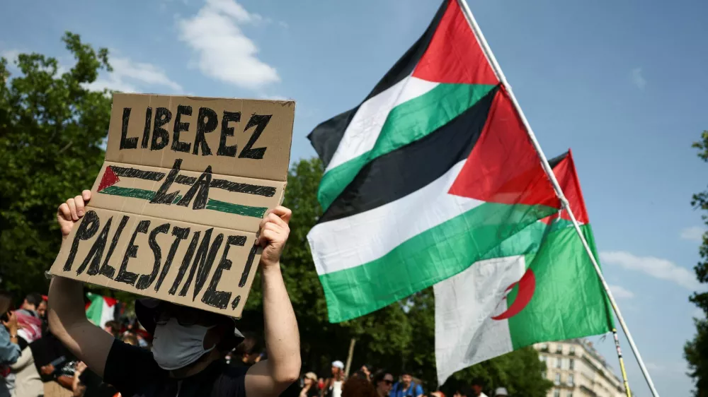 A man holds a placard reading "Free Palestine" during a demonstration, to protest after Israeli forces seize the British-flagged yacht, Madleen, which is operated by the pro-Palestinian Freedom Flotilla Coalition, was aiming to deliver a symbolic amount of aid to Gaza later on Monday and raise international awareness of the humanitarian crisis there, at the Place de la Republique in Paris, France June 9, 2025. REUTERS/Sarah Meyssonnier