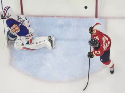 Florida Panthers center Brad Marchand (63) watches as a shot by center Carter Verhaeghe enters the goal against Edmonton Oilers goaltender Stuart Skinner (74) during the first period of Game 3 of the NHL Stanley Cup final Monday, June 9, 2025, in Sunrise, Fla. (AP Photo/Lynne Sladky)