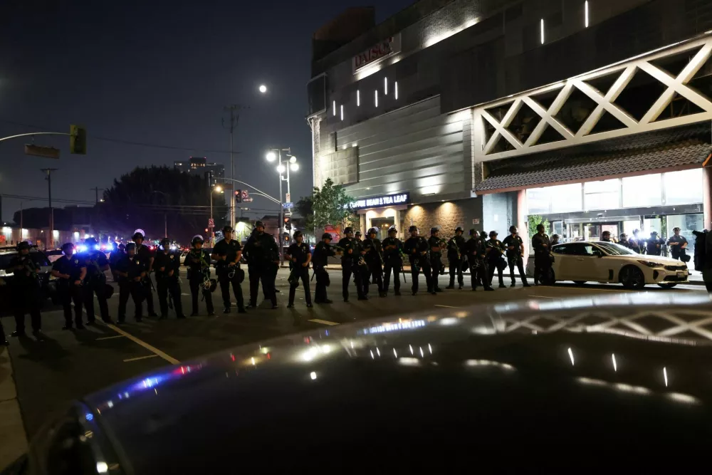 Law enforcement officers stand guard during a protest against federal immigration sweeps in downtown Los Angeles, California, U.S. June 9, 2025. REUTERS/Aude Guerrucci REFILE - CORRECTING FROM "FEDERAL IMMIGRATION" TO "FEDERAL IMMIGRATION SWEEPS".