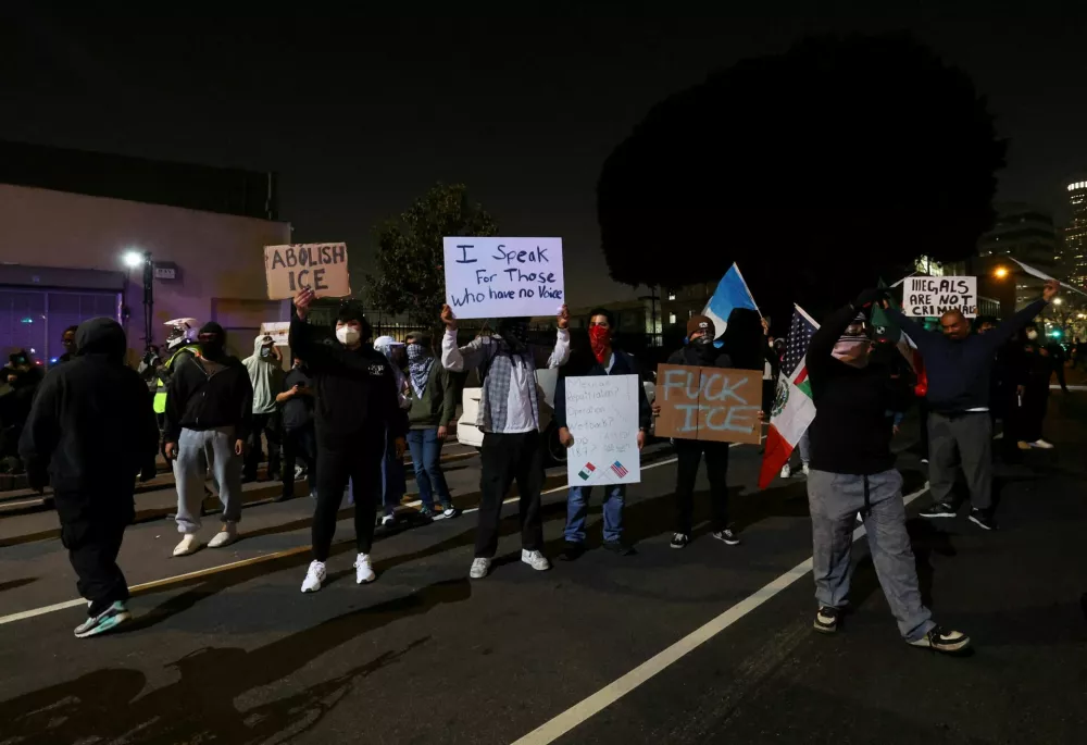 SENSITIVE MATERIAL. THIS IMAGE MAY OFFEND OR DISTURB Demonstrators hold up signs in a protest against federal immigration sweeps, in downtown Los Angeles, California, U.S. June 9, 2025. REUTERS/Aude Guerrucci REFILE - CORRECTING FROM "FEDERAL IMMIGRATION" TO "FEDERAL IMMIGRATION SWEEPS".