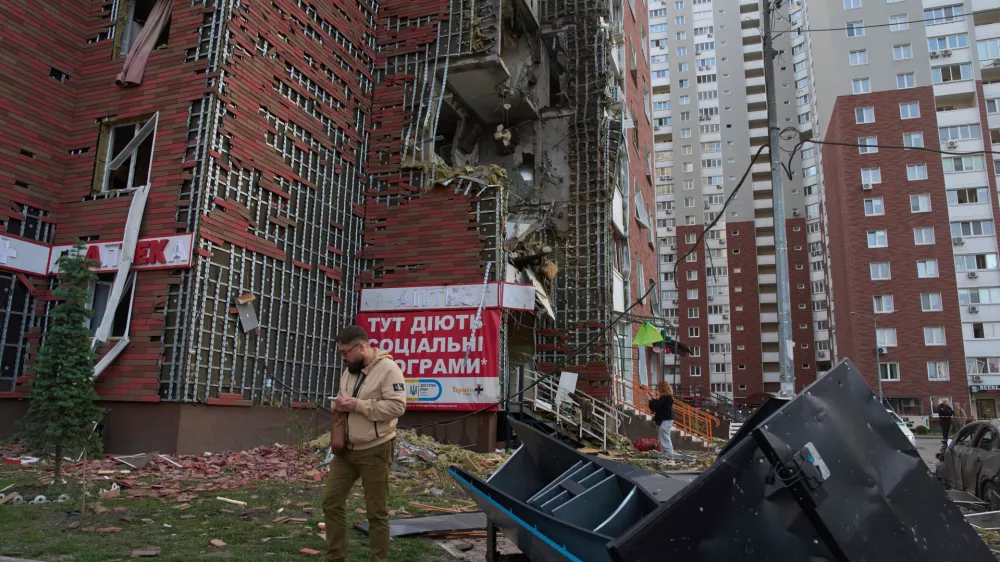 Residents react near their damaged multi-storey building damaged in Russia's massive missile and drone attack in Kyiv, Ukraine, Tuesday, June 10, 2025. (AP Photo/Efrem Lukatsky)