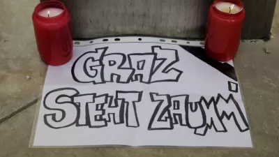 Candles lights next to a piece of paper with the words: "Graz stands together", laced at the cathedral, after a shooting at a school in Graz, Austria, Tuesday, June 10, 2025. (AP Photo/Heinz-Peter Bader)
