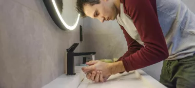 Young man carefully washes his hands in a modern bathroom, promoting hygiene, health, and responsible daily habits in a clean and organized environment. High quality photo / Foto: Stockseller_ukr