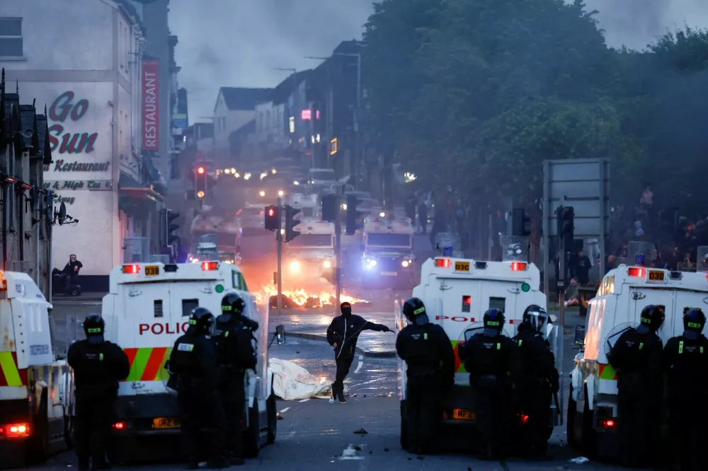 Police officers stand guard behind police vehicles during clashes on the second night of riots, in Ballymena, Northern Ireland, June 10, 2025. REUTERS/Clodagh Kilcoyne   TPX IMAGES OF THE DAY