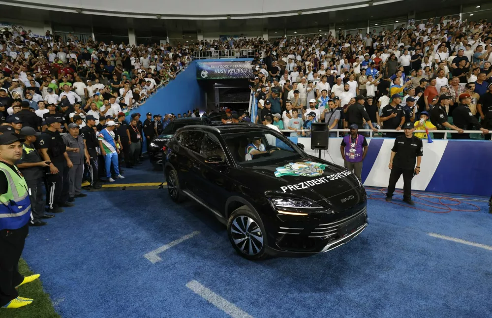 Soccer Football - World Cup - AFC Qualifiers - Group A - Uzbekistan v Qatar - Milliy Stadium, Tashkent, Uzbekistan - June 10, 2025 Uzbekistan President Shavkat Mirziyoyev is driven onto the pitch to honor the national football team after securing a spot at the 2026 FIFA World Cup REUTERS/Maxim Shemetov