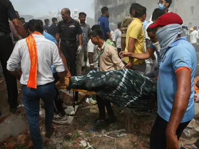 People carry the body of a victim from the crash site after an Air India Boeing 787 Dreamliner plane crashed in Ahmedabad, India, June 12, 2025. REUTERS/Amit Dave   TPX IMAGES OF THE DAY