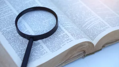 Megnifying glass on page of dictionary. Concept, Word searching. Education