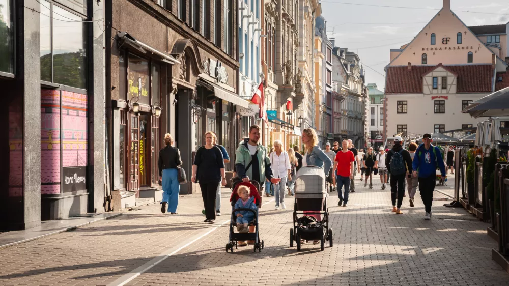 Picture of a typical Old riga street, in Latvia, with a family, pedestrians, mother, father ad babies in strollers, walking. Vecriga (Old Riga) is the historical center and a neighbourhood (as Vecpilseta) of Riga, Latvia, located in the Central District on the east side of Daugava River. Vecriga is famous for its old churches and cathedrals, / Foto: Balkanscat