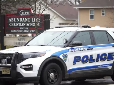 Emergency vehicles are parked outside the Abundant Life Christian School in Madison, Wis., where multiple injuries were reported following a shooting, Monday, Dec. 16, 2024. (AP Photo/Morry Gash)