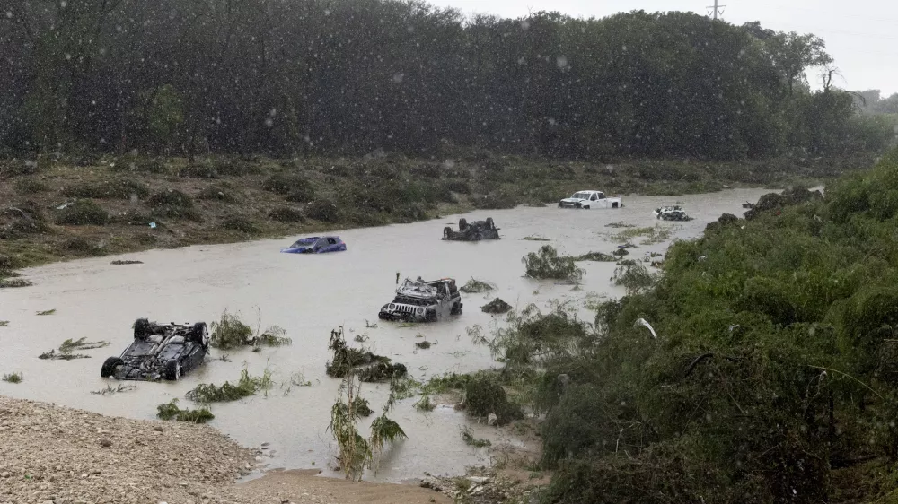 Multiple damaged cars are seen in flood waters Thursday, June 12, 2025, after heavy rains overnight in San Antonio. (Jessica Phelps/The San Antonio Express-News via AP)