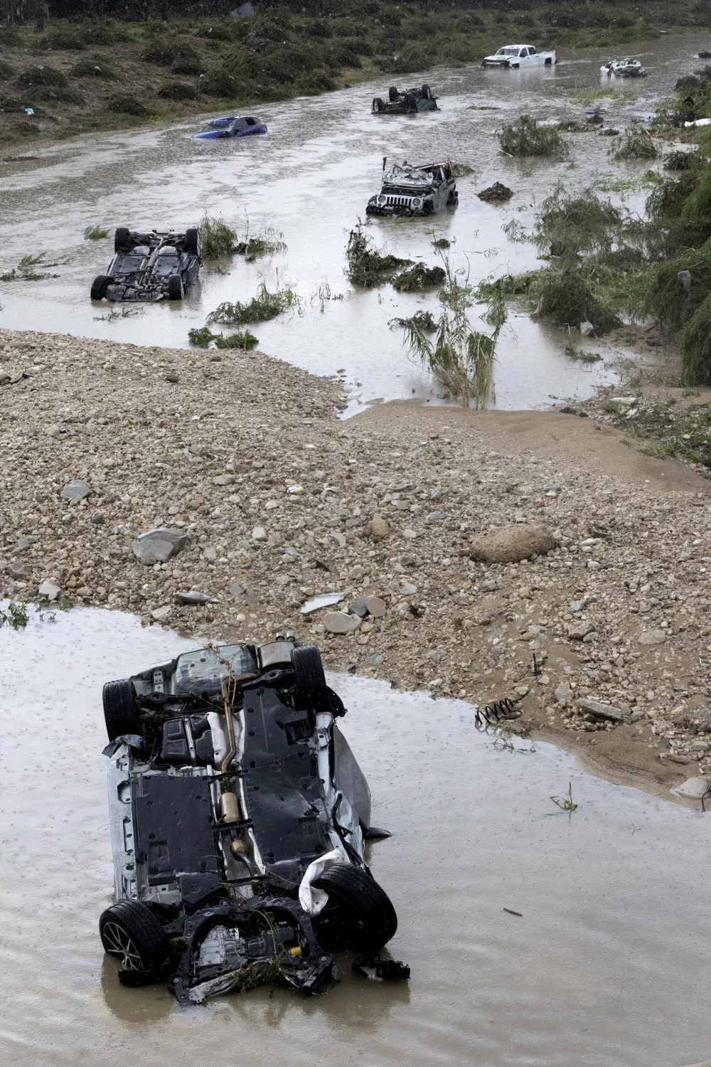 Multiple damaged cars are seen in flood waters Thursday, June 12, 2025, after heavy rains overnight in San Antonio. (Jessica Phelps/The San Antonio Express-News via AP)