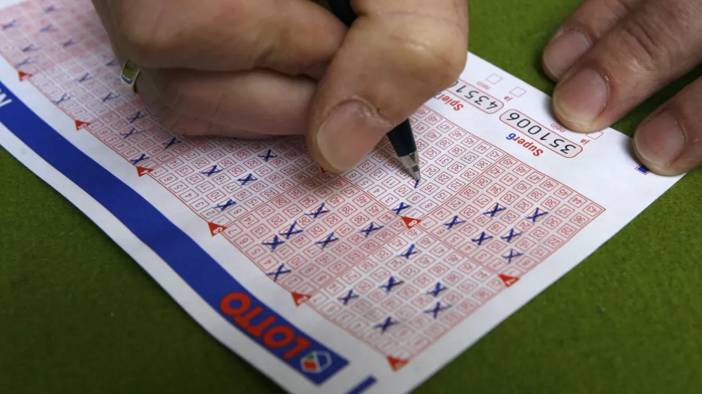 A man fills in a lottery ticket at a Lotto receiving office in Dortmund October 6, 2006. This Saturday the German public lottery 'Lotto' will distribute a total of around 35 million euros, which is the highest lottery jackpot in Germnay since the start of Lotto in 1955.    REUTERS/Ina Fassbender (GERMANY)