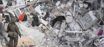 An Israeli military working dog searches rubble for survivors in a residential area hit by a missile fired from Iran, near Tel Aviv, Israel, Sunday, June 15, 2025.(AP Photo/Ariel Schalit)
