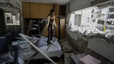 Maryn Mahtiov gathers her belongings from her apartment in Bat Yam, central Israel, after it was struck by an Iranian missile on Sunday, June 15, 2025. (AP Photo/Baz Ratner)