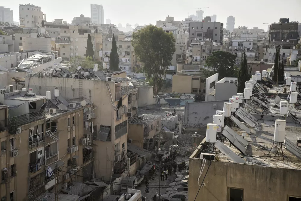 Rescue workers, police and military inspect the site where an Iranian missile struck in Bnei Brak, near Tel Aviv, Israel, Monday, June 16, 2025. (AP Photo/Leo Correa)