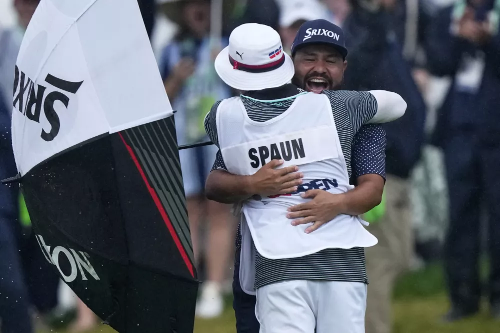 J.J. Spaun celebrates by hugging his caddie, Mark Carens, after making a birdie putt on the 18th hole to win the U.S. Open golf tournament at Oakmont Country Club Sunday, June 15, 2025, in Oakmont, Pa. (AP Photo/Charlie Riedel)