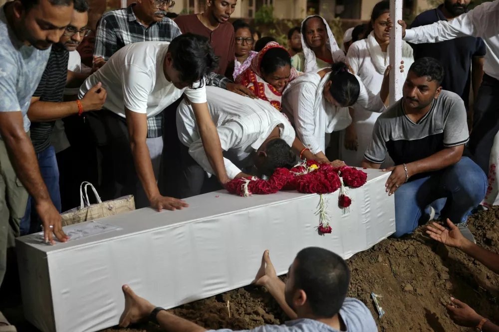 Relatives of Rozar David Christian, who lost his life in an Air India Boeing 787-8 Dreamliner plane crash, lower a coffin containing his remains, during burial, at a cemetery in Ahmedabad, India June 15, 2025. REUTERS/Amit Dave