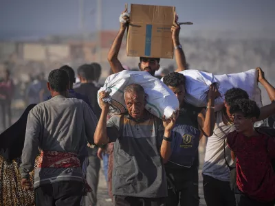 Palestinians carry sacks and boxes of food and humanitarian aid unloaded from a World Food Program convoy that had been heading to Gaza City, in the northern Gaza Strip, Monday, June 16, 2025. (AP Photo/Jehad Alshrafi) / Foto: Jehad Alshrafi