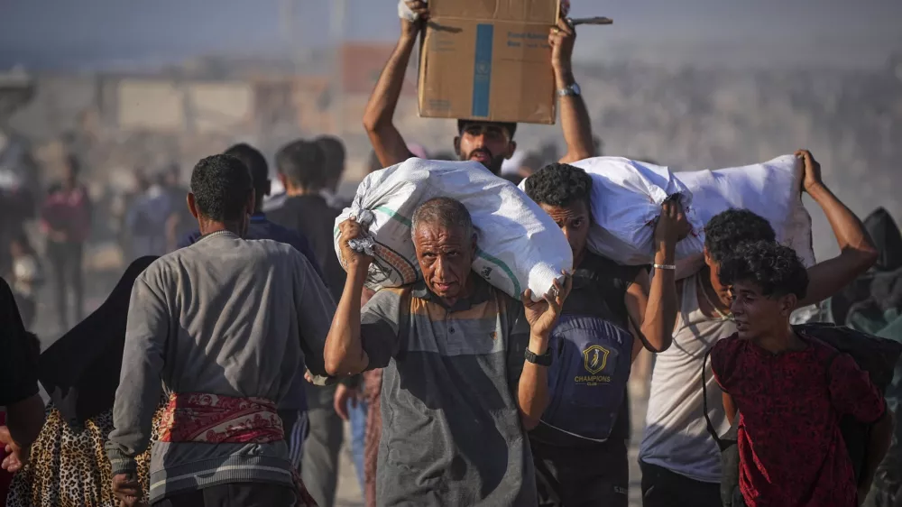 Palestinians carry sacks and boxes of food and humanitarian aid unloaded from a World Food Program convoy that had been heading to Gaza City, in the northern Gaza Strip, Monday, June 16, 2025. (AP Photo/Jehad Alshrafi) / Foto: Jehad Alshrafi