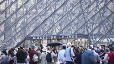 Tourists wait outside the Louvre museum which failed to open on time Monday, June 16, 2025 in Paris. (AP Photo/Christophe Ena)