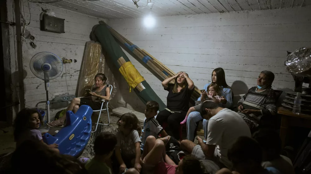 Israelis take shelter during air raid sirens warning of incoming strikes by Iran, in Bnei Brak, near Tel Aviv, Israel, Tuesday, June 17, 2025. (AP Photo/Oded Balilty)