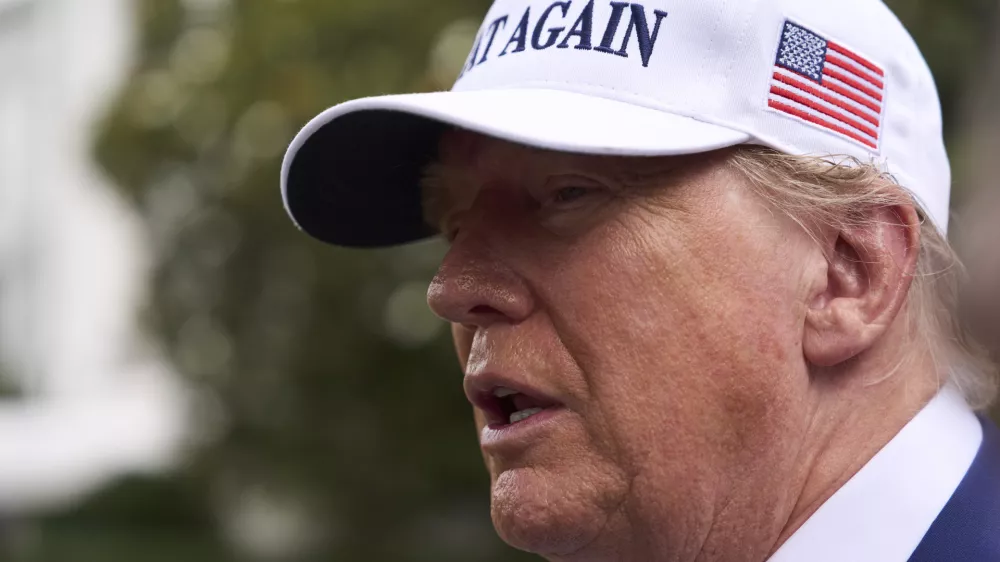 President Donald Trump speaks with reporters as a flag pole is installed on the South Lawn of the White House, Wednesday, June 18, 2025, in Washington. (AP Photo/Evan Vucci)