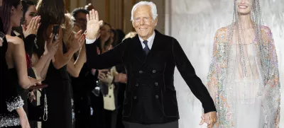 FILE - Giorgio Armani gestures at the end of the Giorgio Armani Prive Haute Couture Spring Summer 2025 collection in Paris, on Jan. 28, 2025. (AP Photo/Lewis Joly, File).