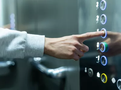 Closeup of person's hand pushing button to select first floor in elevator. Passenger lift. Businessman in office. Movement within building concept