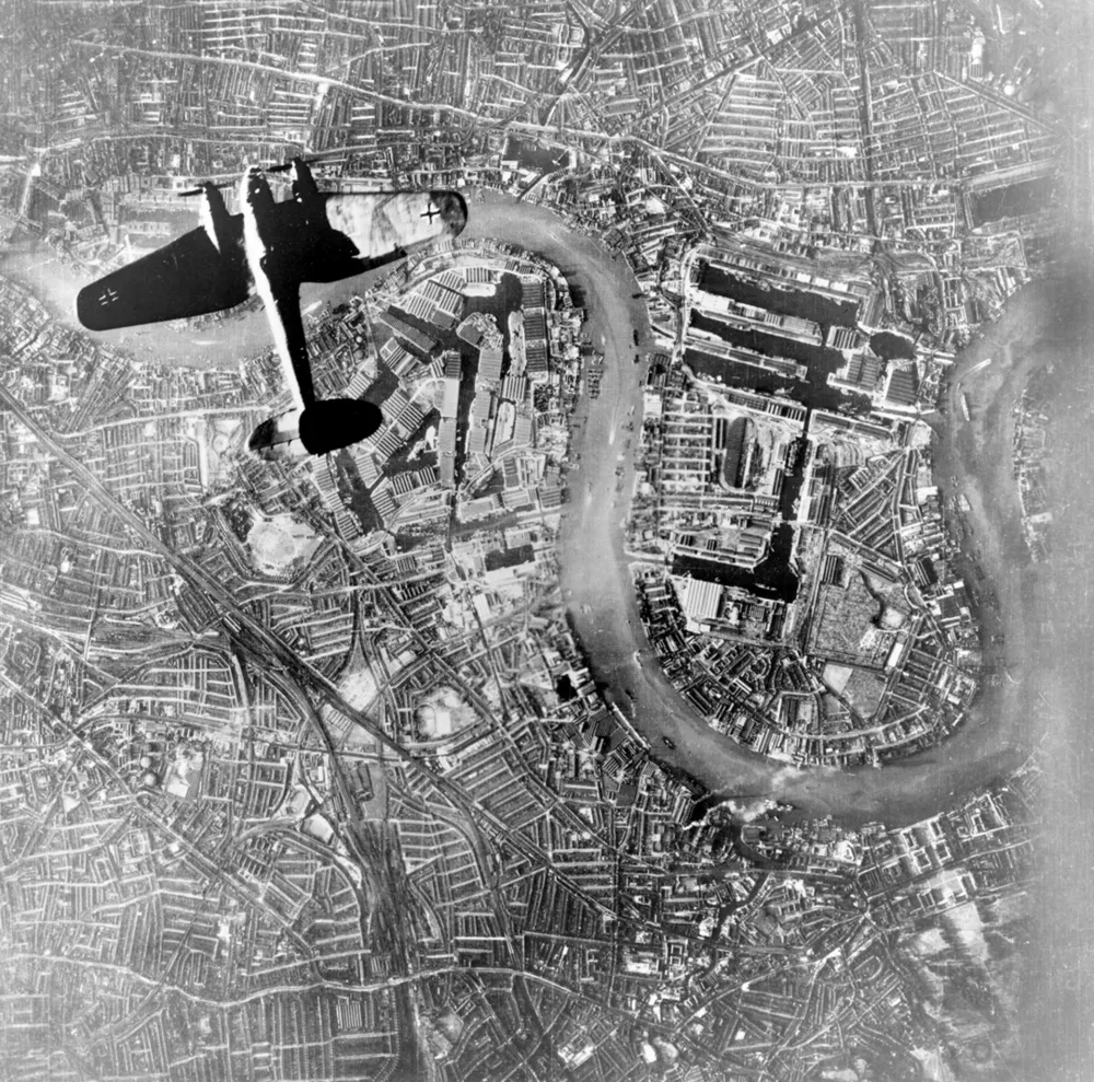 Kopija negativa dela zračne fotografije, posnete z nemškega letala ob 18.48 po nemškem času, na kateri vidimo nemški bombnik Luftwaffe Heinkel He 111, ki leti nad Wappingom in otokom Isle of Dogs v vzhodnem delu Londona na začetku večernih napadov. / Foto: Wikipedija