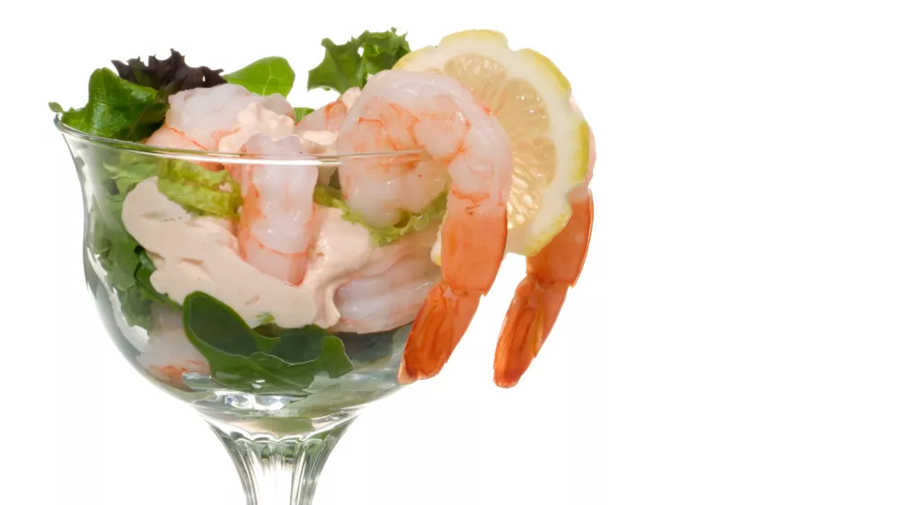 Closeup of delicious Prawn Cocktail. Fresh jumbo shrimps, cream, lettuce leaves, lemon wedge and zesty sauce. Appetizer served in cocktail glass. Copyspace.. / Foto: Evgenyb