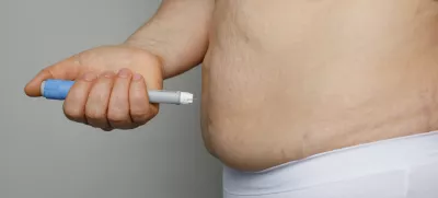 Weight Loss concept. Woman with Semaglutide Injection Pen and her Stomach closeup indoor / Foto: Jnemchinova